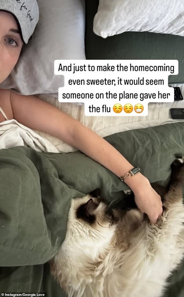 She shared a picture of herself to her Instagram Stories on Wednesday as she rested in bed with the flu, cuddling up with her ragdoll cat as she recovered