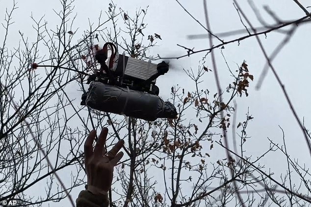 In this photo taken from a video released by Russian Defense Ministry press service on Monday, Nov. 25, 2024, Russian serviceman launches a FPV-drone towards Ukrainian position in an undisclosed location