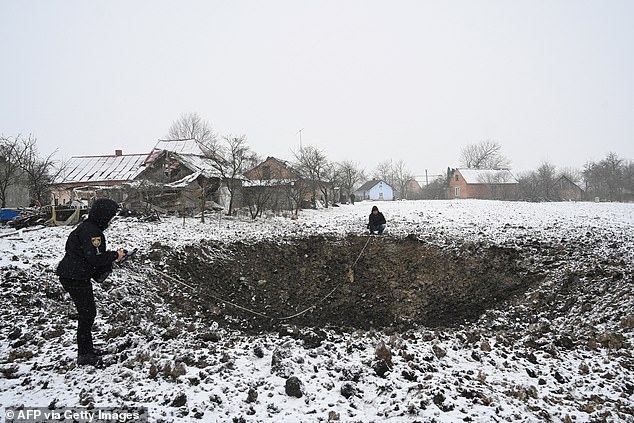 Members of the Ukrainian police investigate a crater following a strike on the village of Sknyliv, some 60km from Lviv, on January 15