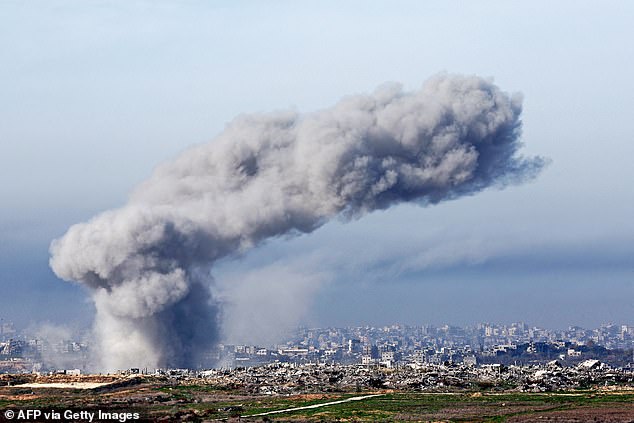 Smoke plumes rising from explosions above destroyed buildings in the northern Gaza Strip on January 14, 2025