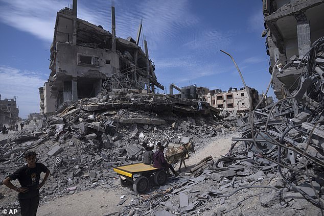 Palestinians salvage what they can from the destruction left by Israeli troops in Khan Younis, southern Gaza Strip, on April 8