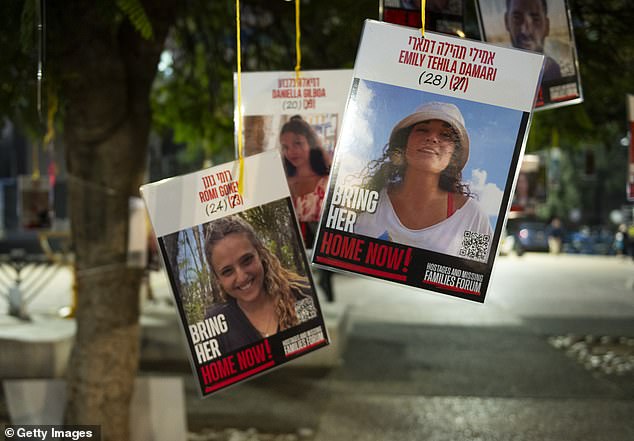 Posters of hostages Emily Tehila Damari, Romi Gonen and Daniella Gilboa are hung at Hostage Square after a Gaza ceasefire and hostage release deal was reached on January 16, in Tel Aviv