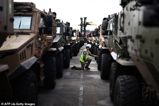 A member of the military checks the tyres on a Foxhound vehicle in Southampton, January 16