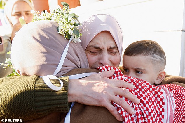 Freed Palestinian prisoner Nidaa Zaghebi embraces her mother-in-law and son after her release from an Israeli jail as part of a hostages-prisoners swap