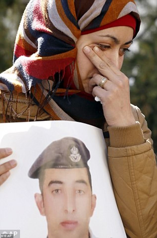 The pilot's wife Anwar Tarawneh, holds a photo of him before his grotesque execution was confirmed