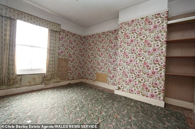 Two of the larger bedrooms are covered in vintage floral print wallpaper and vibrant pattered carpets