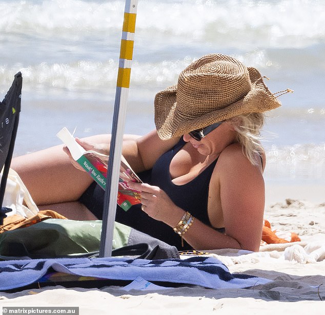 She flaunted her Pilates-honed physique as she stripped down to her swimwear while reading a book about a 'wronged wife' after her own cheating heartbreak