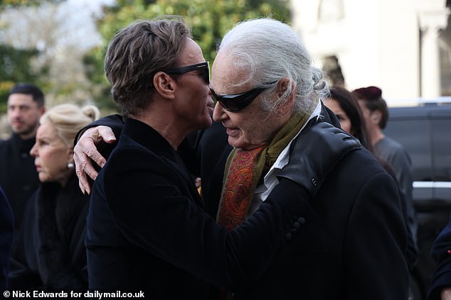 Her partner Lloyd was embraced by dozens of tearful grievers dressed in fashionable outfits before the group of mourners headed into the crematorium