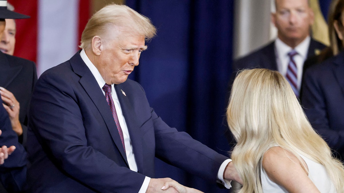 Country singer Carrie Underwood shakes hands US President Donald Trump after performing ‘America the Beautiful’ during Trump’s inauguration ceremony