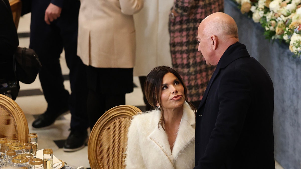 Lauren Sanchez wearing a fuzzy coat and looking up at Jeff Bezos.