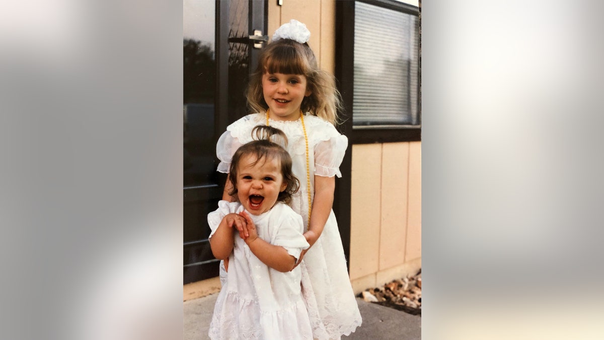 Jinger Duggar smiling and being held by her older sister Jill Duggar