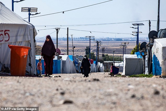 People walk around at Camp Roj, where relatives of people suspected of belonging to the Islamic State (IS) group are held, in the countryside near al-Malikiyah (Derik) in Syria's northeastern Hasakah province on October 8, 2023