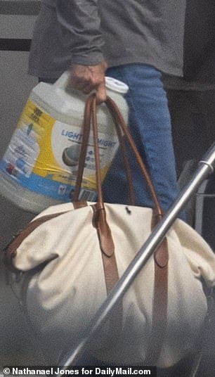 A man carries cat litter onto the plane