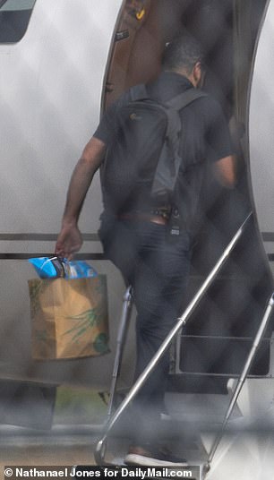 A man carries snacks onto the plane