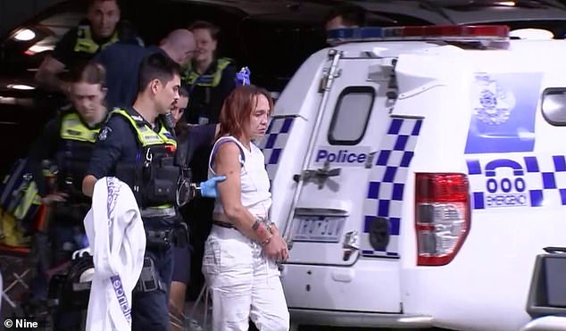 The woman was led from the 7-Eleven in inner-city Melbourne in handcuffs