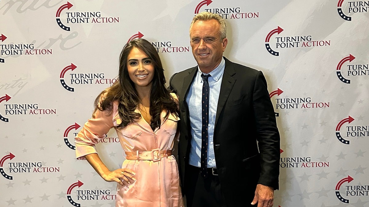 Woman in pink dress standing next to RFK Jr.